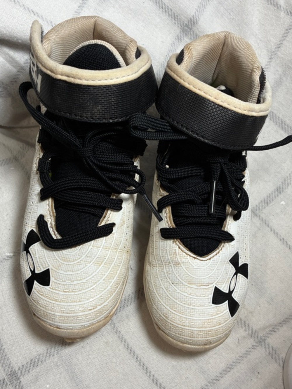 Under Armour Kids White and Black Mid-Top sports cleats and